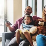 Familie kijkt samen naar tv vanuit de zetel