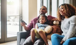 Familie kijkt samen naar tv vanuit de zetel