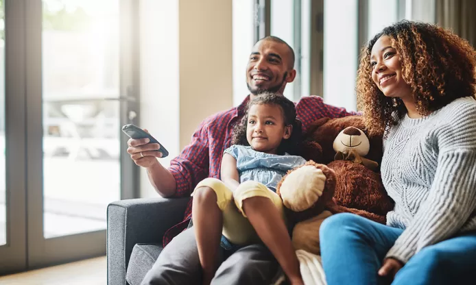 Familie kijkt samen naar tv vanuit de zetel