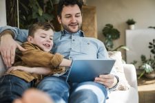 man en zoon in zetel met tablet