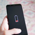 Man kijkt naar smartphone met lege batterij