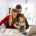 Vader bekijkt rekening met kinderen op schoot
