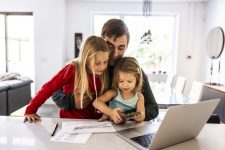 Vader bekijkt rekening met kinderen op schoot