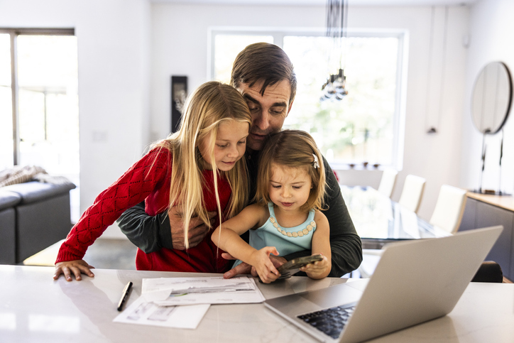 Vader bekijkt rekening met kinderen op schoot