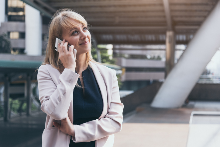 Vrouw belt met smartphone en ziet er opgelucht uit