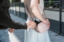Un pickpocket vole un smartphone du sac à main d'une femme