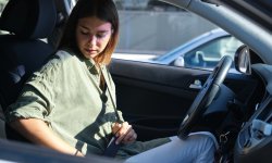 Vrouw doet haar gordel om in de auto.