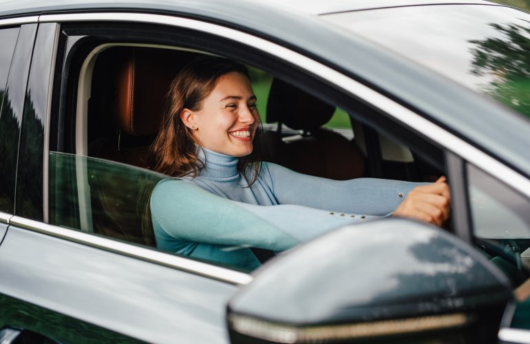 Jeune femme achetant sa première voiture. Concept de première acquisition automobile.