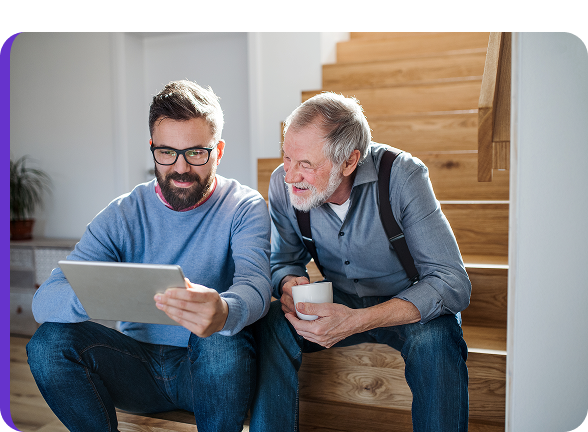 Twee mannen die samen op een trap naar een tablet kijken, als illustratie van het vergelijken van verzekeringen of diensten.